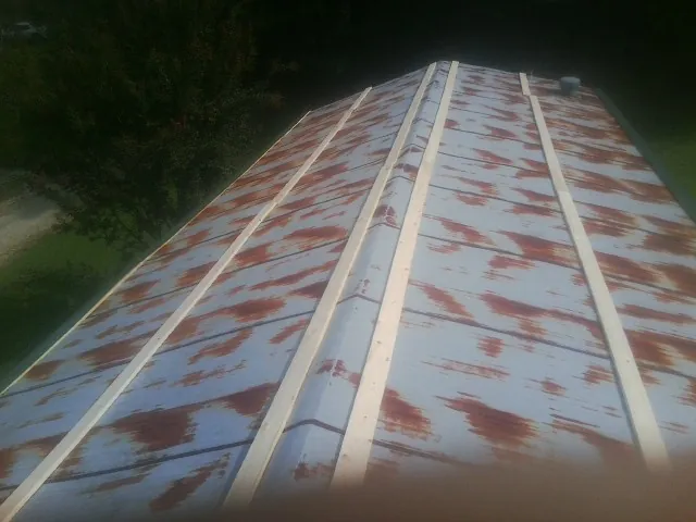 Rusted metal roof panels with new wood purlins before replacement — Storm Damage Roof Repair in Ophiem by Roofing Brothers