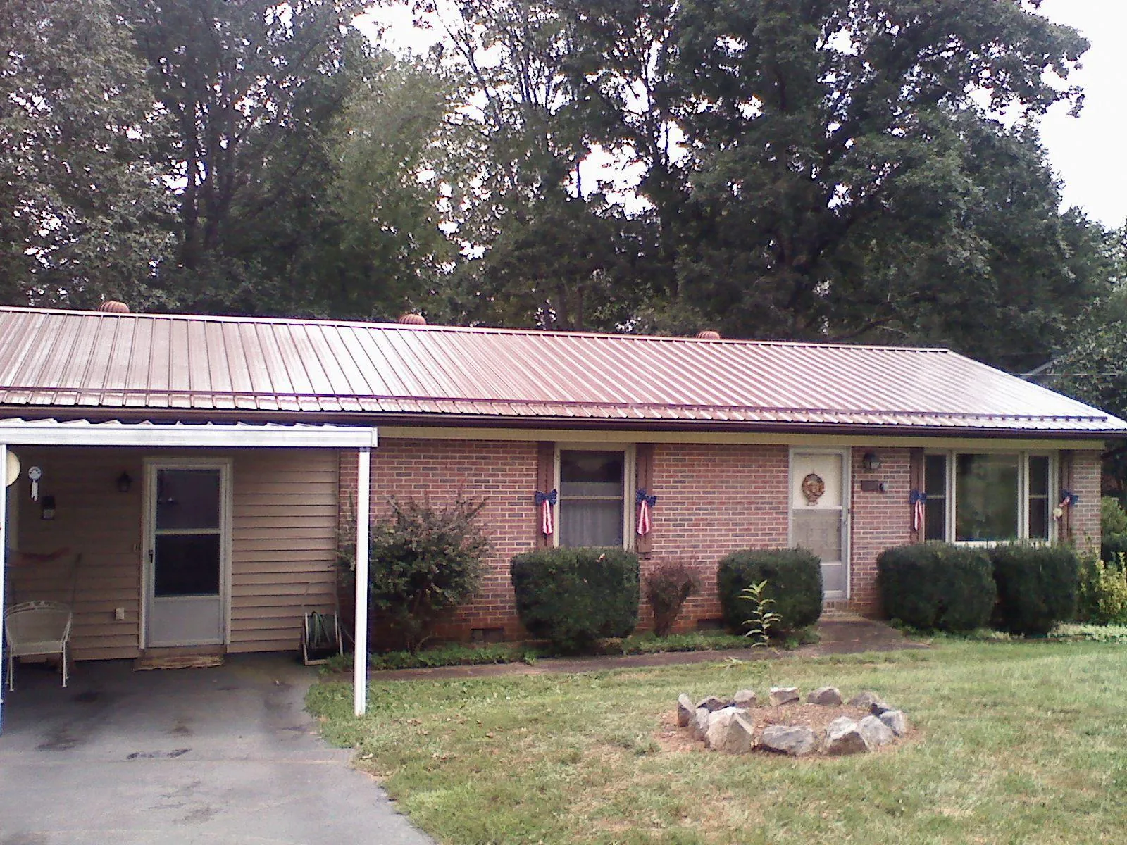 Bronze metal roof and carport on a brick ranch home — Roof Repair work by our crew in Ophiem
